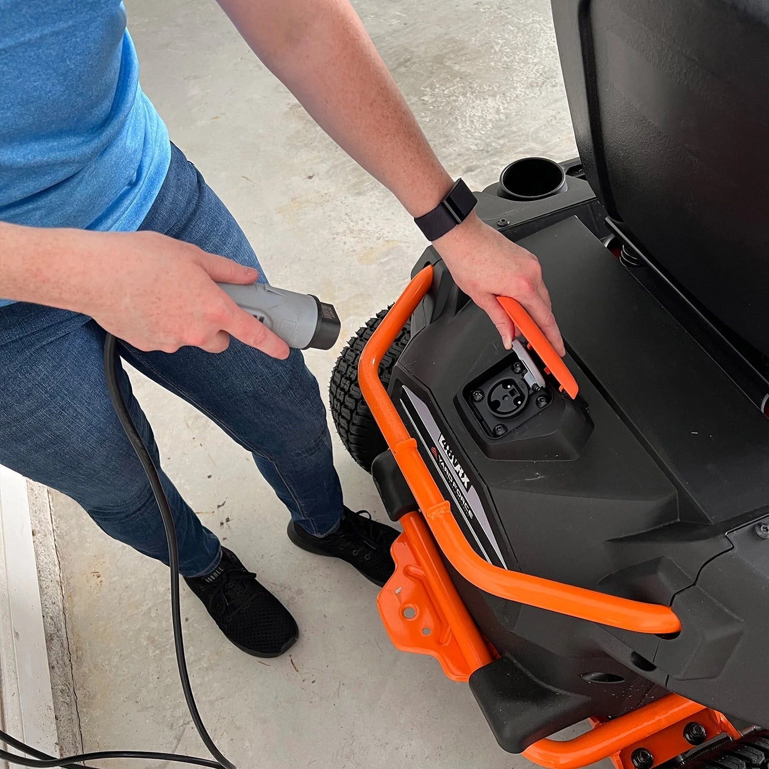 Person using a power tool on a lawn mower