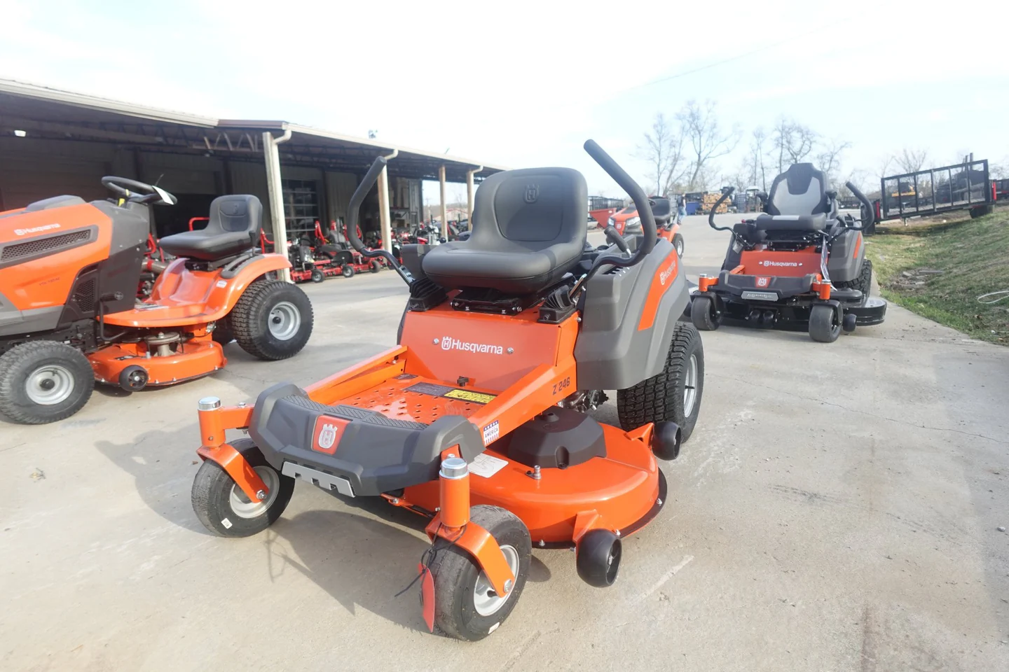 Husqvarna riding lawn mowers on display outdoors with a building in the background.