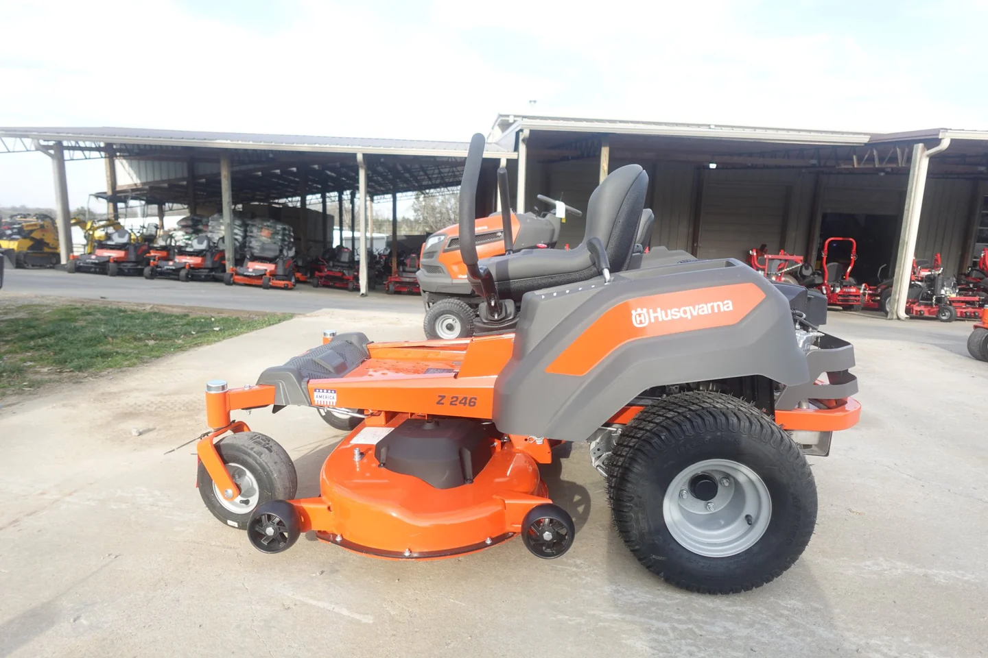 Orange and gray riding lawn mower with 'Bobcat' branding on a concrete surface.