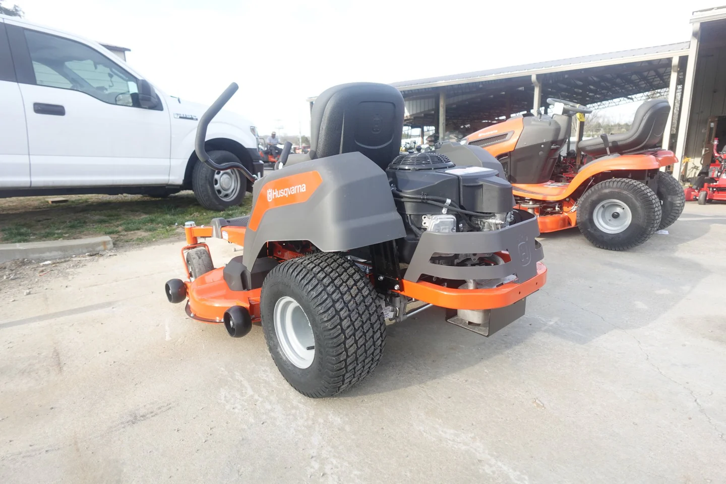 Bulldog lawn mower on a concrete surface with vehicles in the background