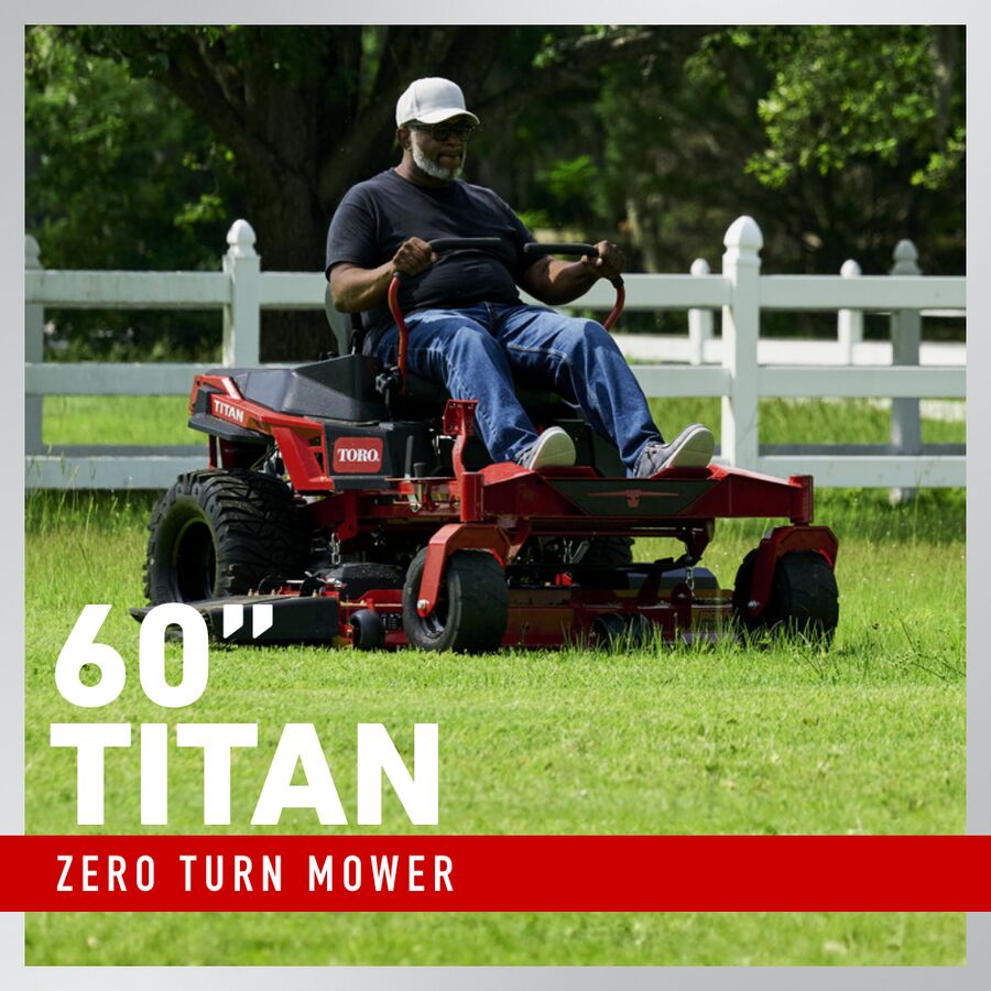 Man operating a Toro 60" Titan zero turn mower in a grassy area with a white fence and trees in the background.