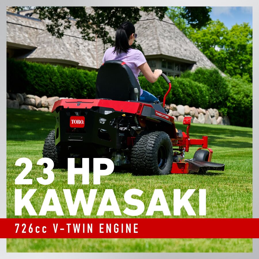 Person operating a red Toro lawn mower with 23 HP Kawasaki engine on a grassy area.

