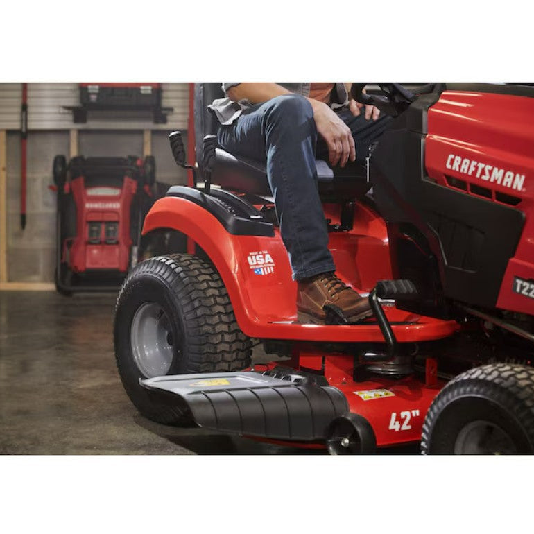 Person sitting on a red Craftsman riding lawn mower in a garage.

