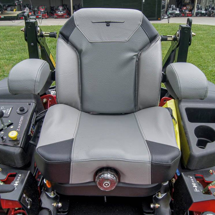 Gray seat of a lawn mower with control panel on grass