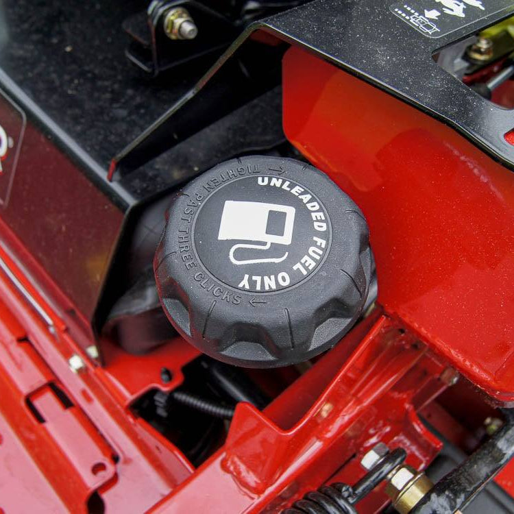 Fuel cap on a red lawn mower with 'Unleaded Fuel Only' label