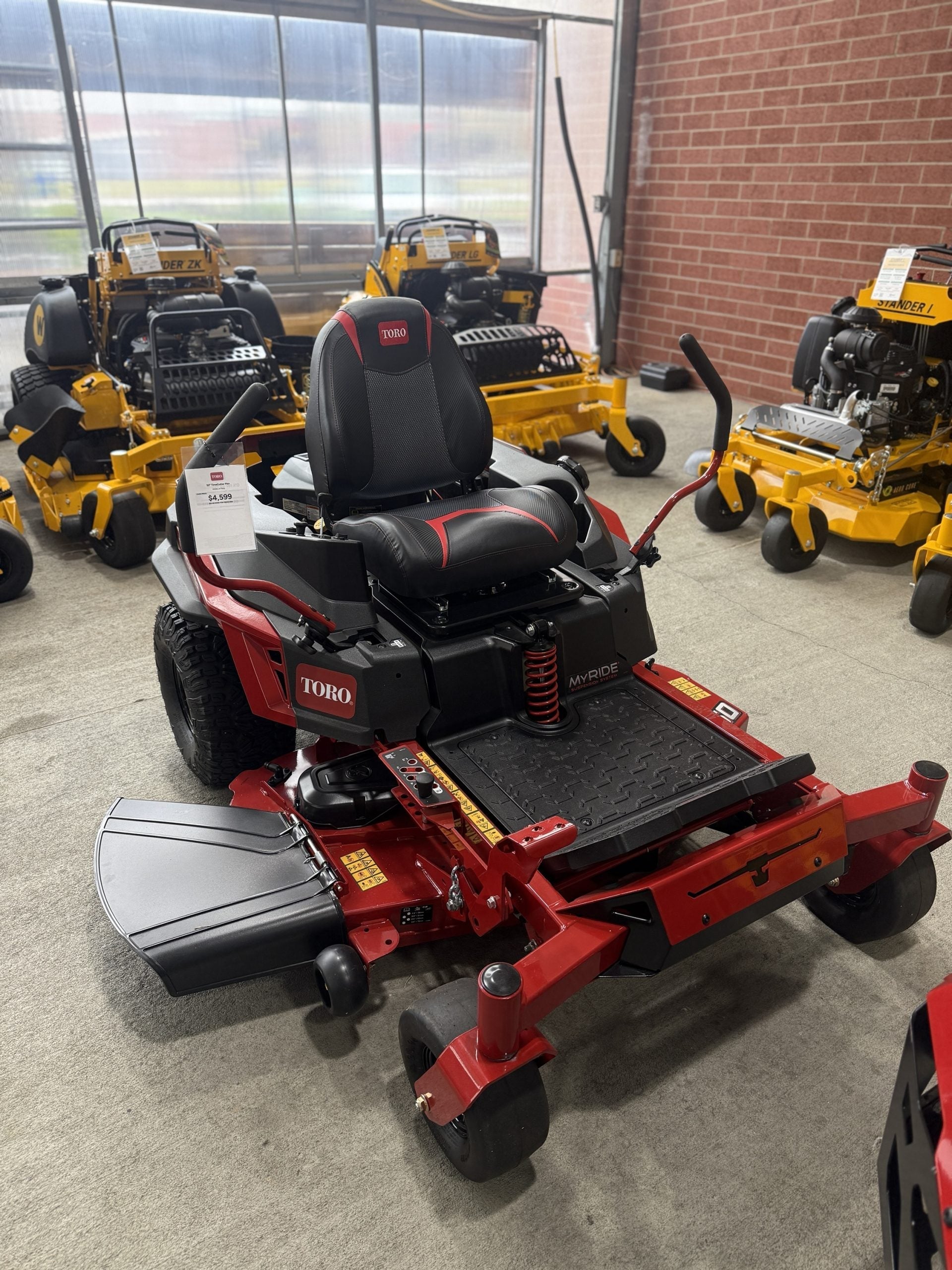 Red Toro lawn mower in a showroom with other mowers in the background.

