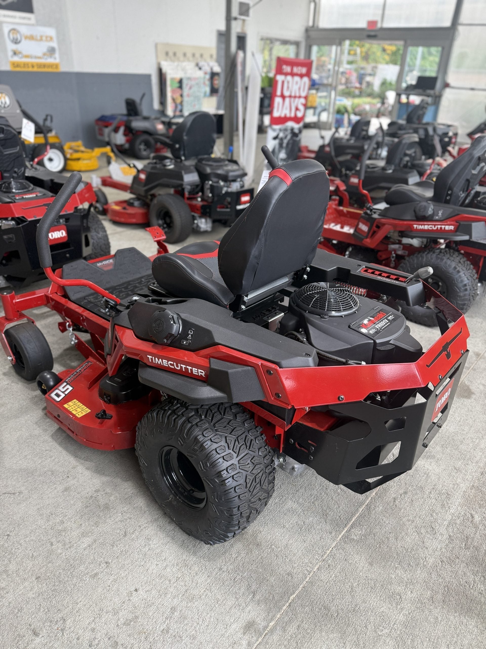 Red and black zero-turn lawn mower in a showroom setting

