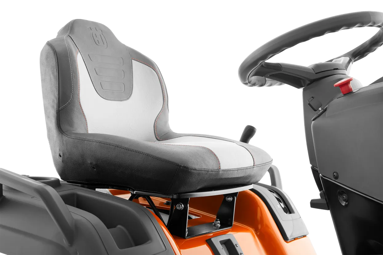 Close-up of a tractor seat and steering wheel on a white background