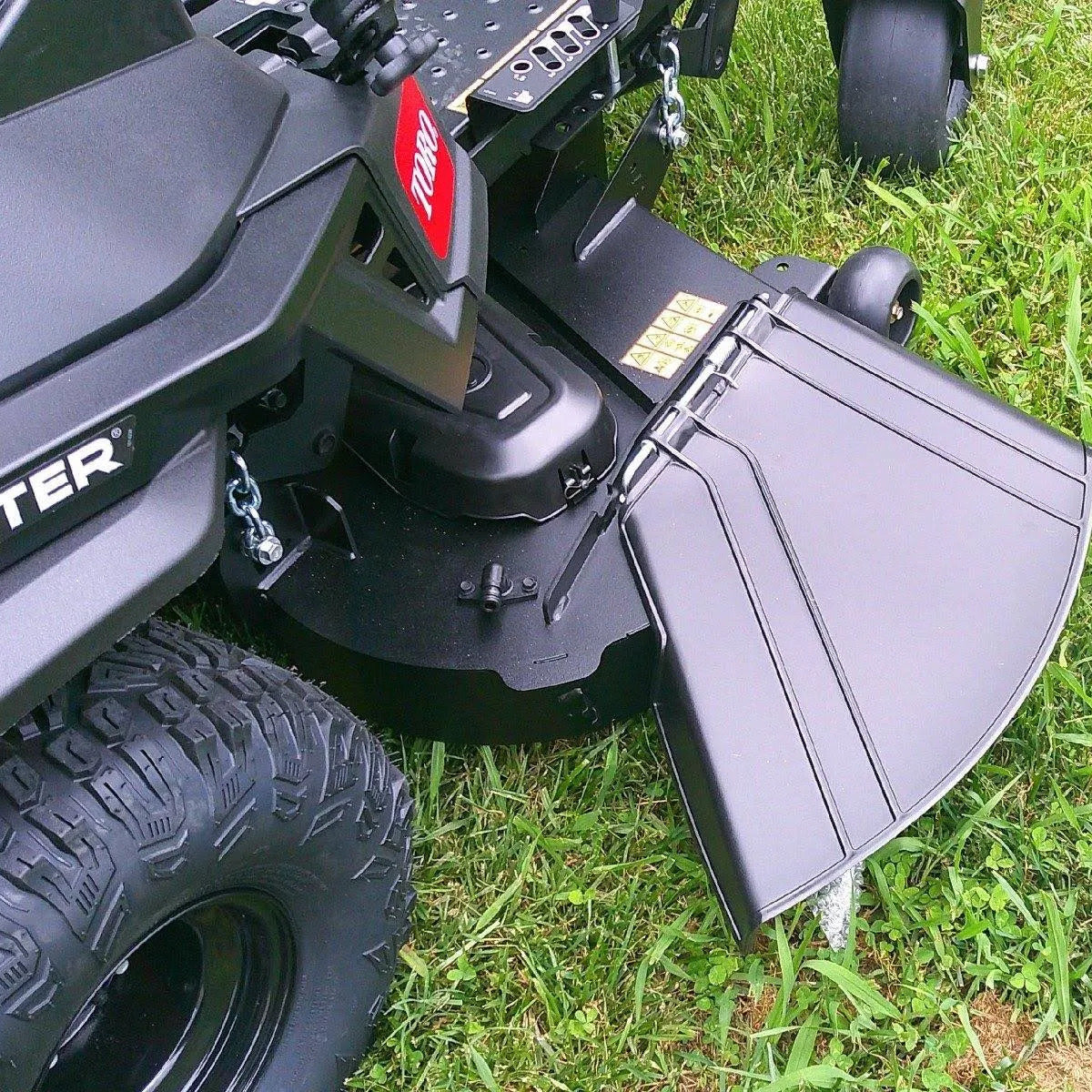 Close-up of a lawn mower deck on grass

