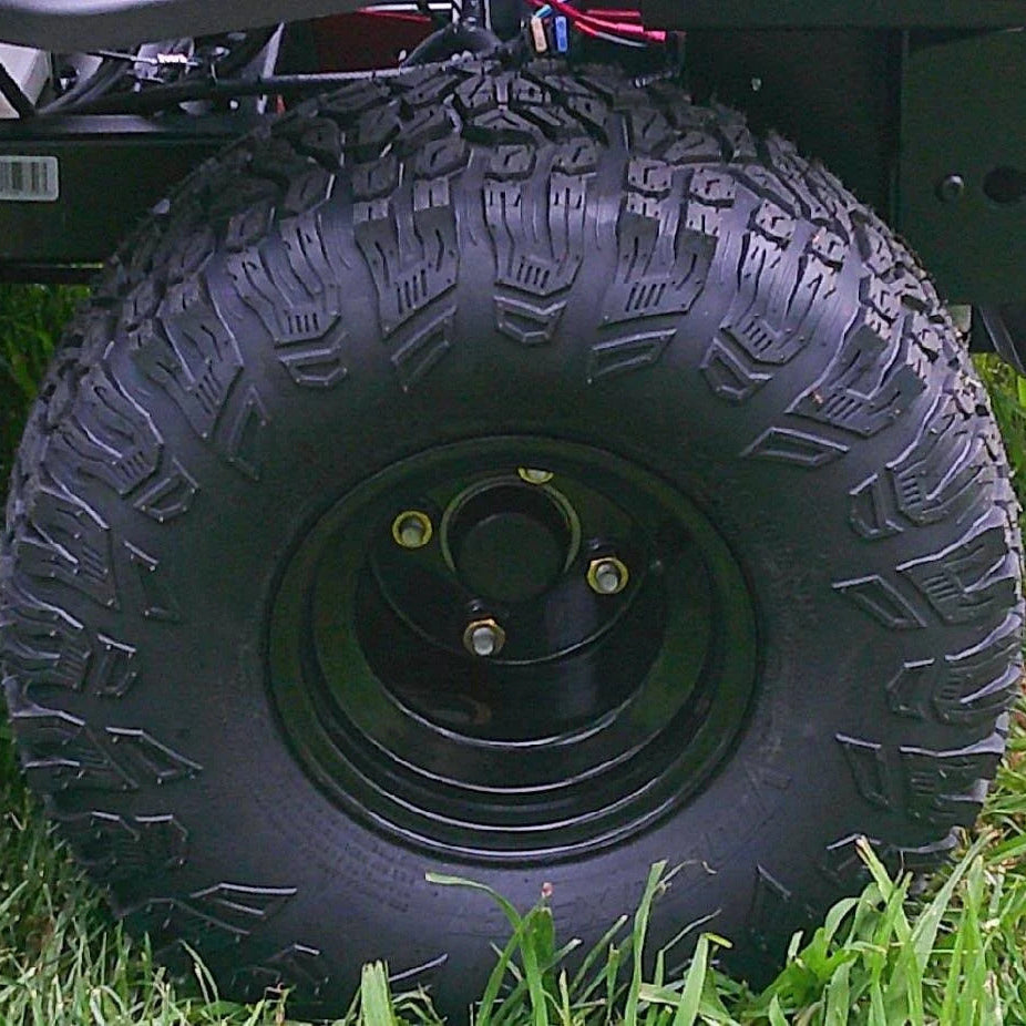 Close-up of a black tire with tread pattern on grass


