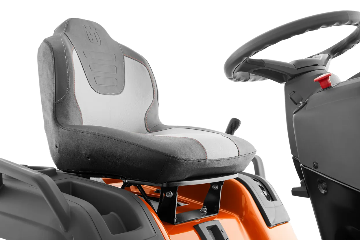 Close-up of a tractor seat and steering wheel on a white background